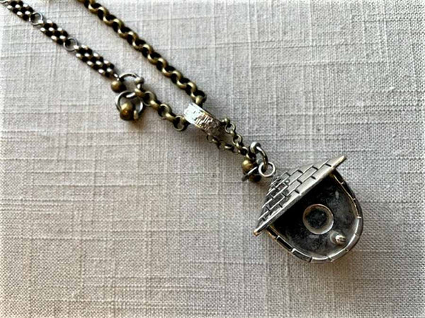 closeup of antique salt shaker birdhouse pendant on chain mix