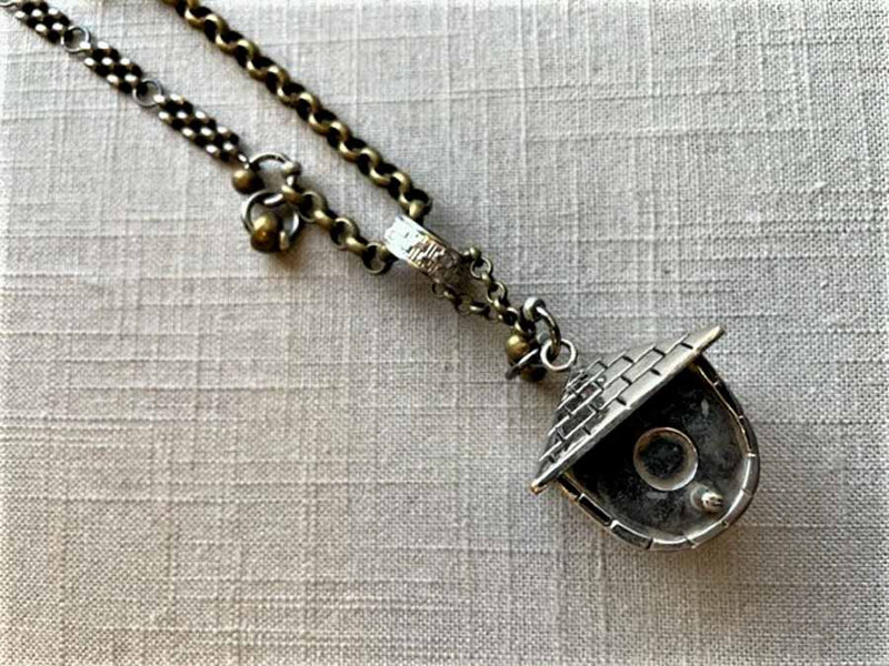 closeup of antique salt shaker birdhouse pendant on chain mix