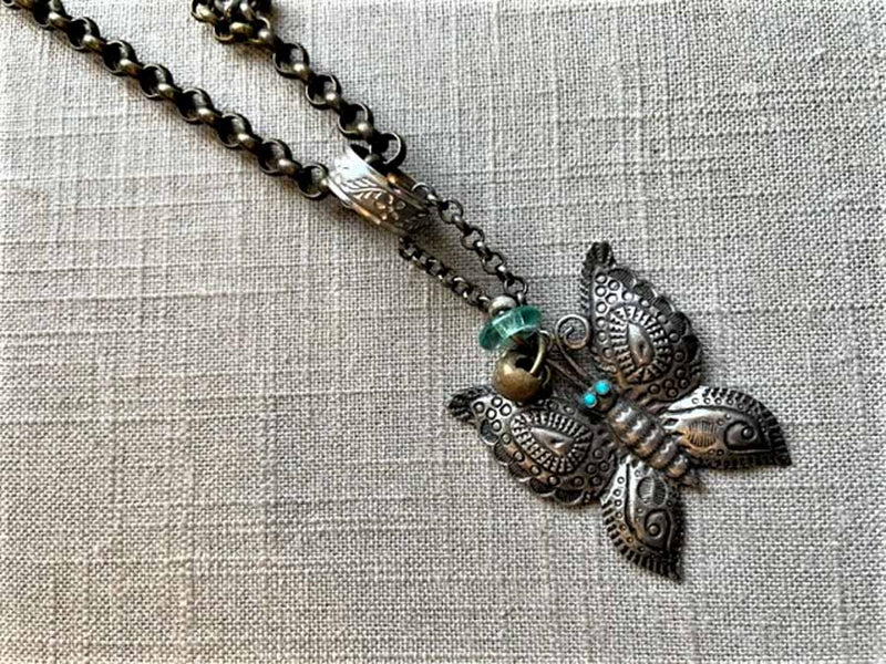 closeup of antique butterfly pendant on chain mix