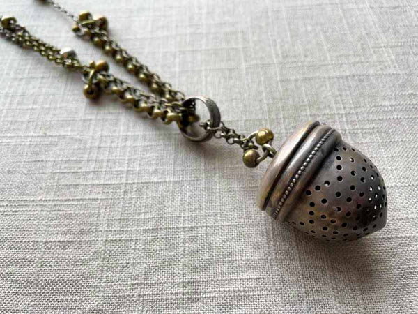 side view of acorn tea caddy pendant on chain mix