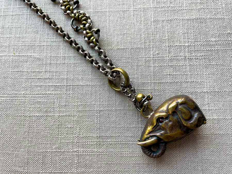 closeup of elephant match safe pendant on chain mix