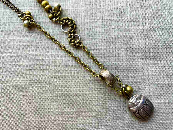 closeup of antique sterling silver scarab pendant on chain mix