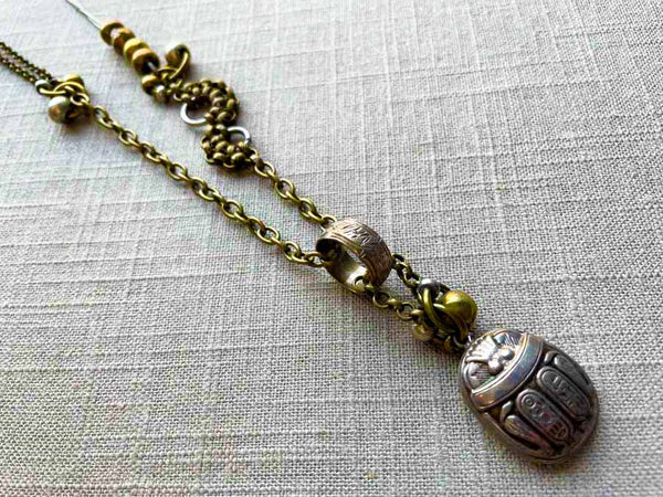 closeup of antique sterling silver scarab pendant on chain mix