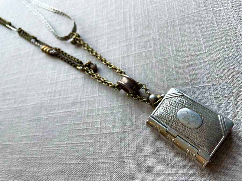 top view of antique book match safe pendant on chain mix