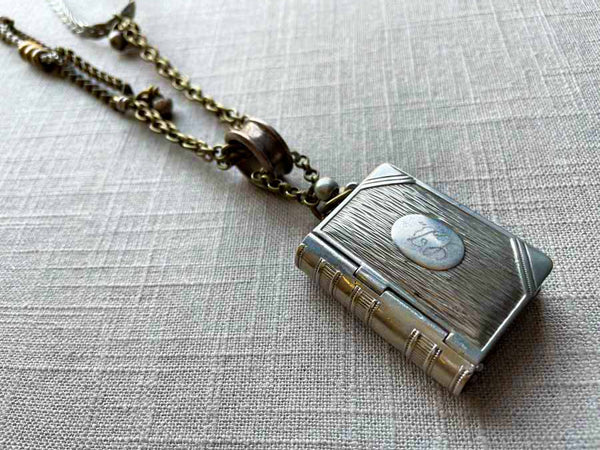 side view of antique book match safe pendant on chain mix