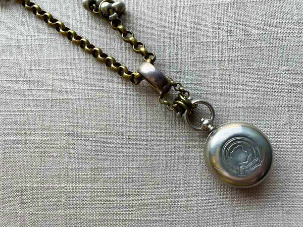 closeup of antique sterling silver single change holder pendant on chain mix