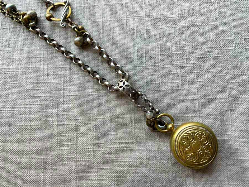 closeup of bronze single change holder pendant on chain mix