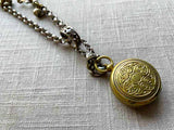 closeup of bronze single change holder pendant on chain mix