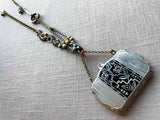 top view of antique sterling silver compact pendant with black enamel on chain mix