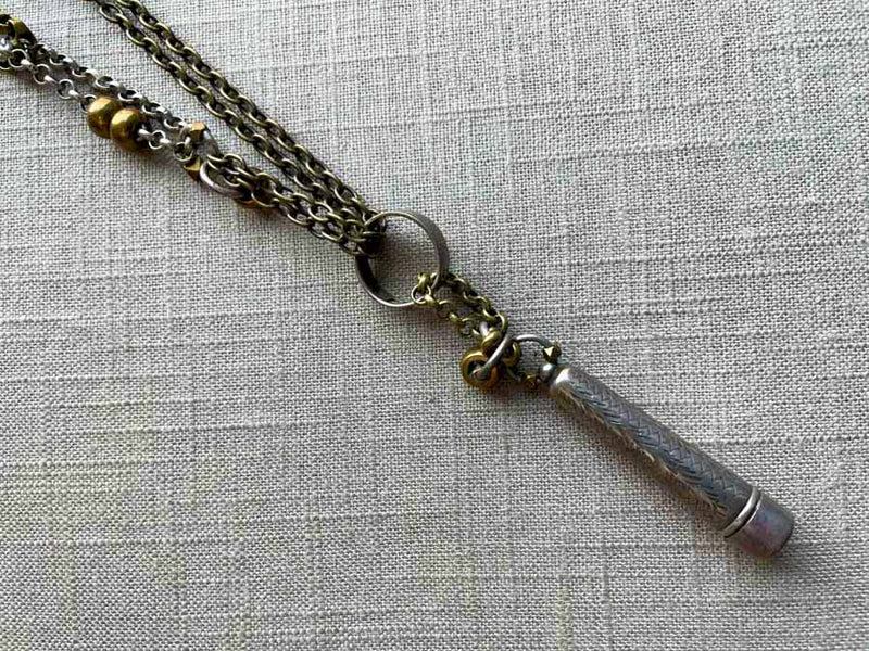 closeup of antique sterling silver telescoping cigarette holder on chain mix