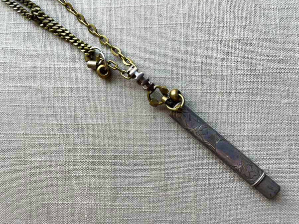 closeup of antique sterling silver pencil holder on chain mix