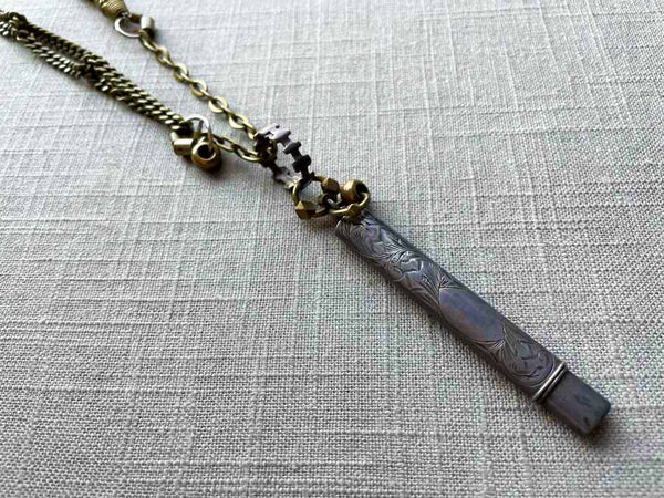 closeup of antique sterling silver pencil holder on chain mix