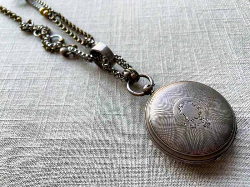 closeup of antique sterling silver pocket watch case on chain mix