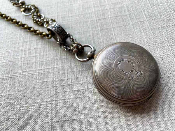 closeup of antique sterling silver pocket watch case on chain mix