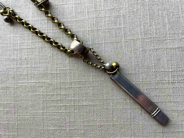 closeup of antique sterling silver pencil holder on chain mix