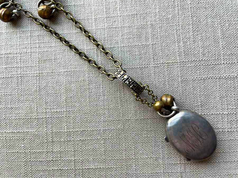 closeup of antique sterling silver locket on chain mix