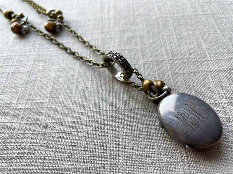 closeup of antique sterling silver locket on chain mix