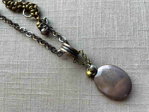 closeup of antique sterling silver locket on chain mix