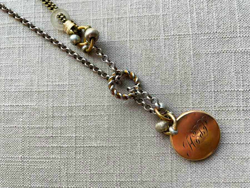 closeup of antique gold-plate locket on chain mix