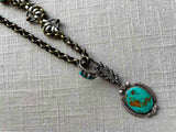 closeup of modern sterling silver turquoise pendant on chain mix