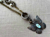 closeup of modern sterling silver butterfly pendant with turquoise on chain mix