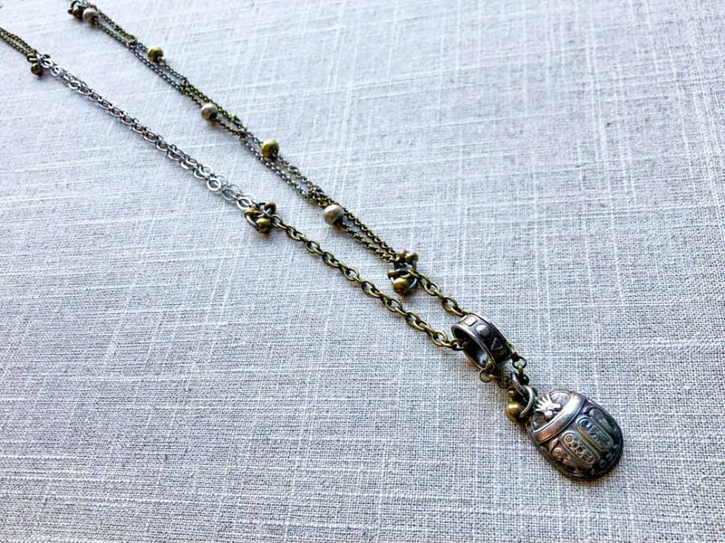 top view of antique sterling silver scarab pendant on chain mix