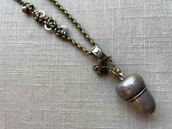 closeup of antique acorn pepper shaker pendant on chain mix